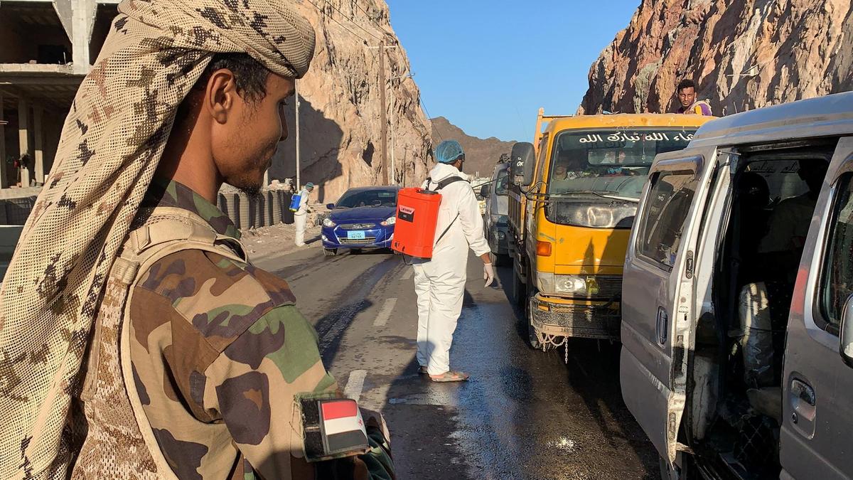 Members of Yemen’s separatist Southern Transitional Council staff a checkpoint while workers disinfect vehicles at the entrance of Mualla, a district of the southern province of Aden, on May 10, 2020. (AFP)