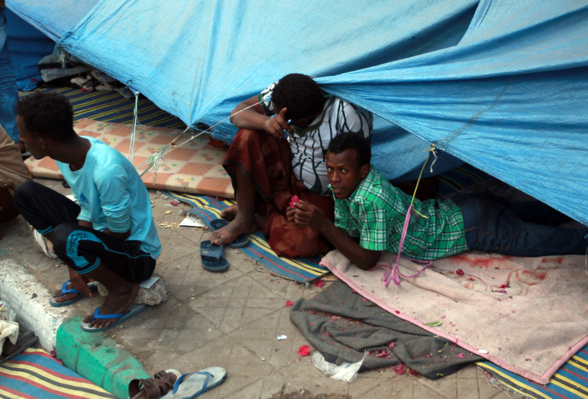 African migrants lay on the ground under a tarpaulin at a makeshift shelter on June 19, 2014, in Sanaa. (AFP file photo) African migrants lay on the ground under a tarpaulin at a makeshift shelter on June 19, 2014, in Sanaa. (AFP file photo)